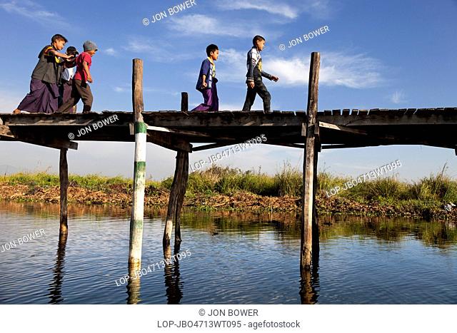 Myanmar, Shan, Lake Inle. Children on a jetty by Lake Inle in Myanmar