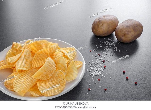 potato chips on a plate with salt and pink pepper