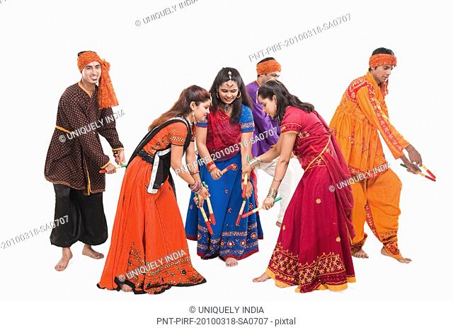 Men and women performing dandiya