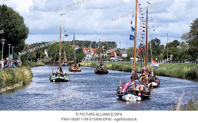 11 August 2018, Germany, Carolinensiel: Traditional sailing ships sail along the Harle River during the ""WattenSail 2018"" event