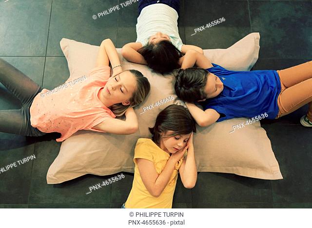 Four children sleeping on a big pillow
