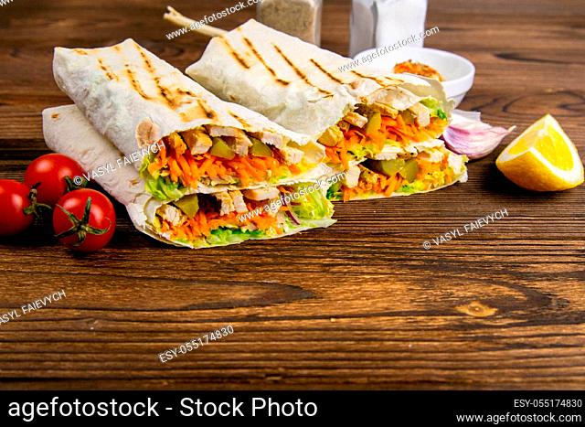 Homemade shawarma, burrito, chicken roll with vegetables and sauce. Front view ingredients