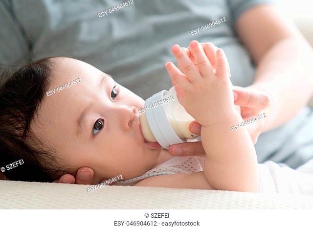 Father bottle feed milk to son
