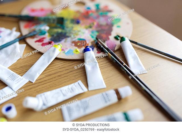 palette, brushes and paint tubes on table