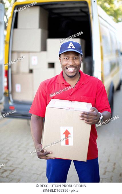 Black delivery man holding package