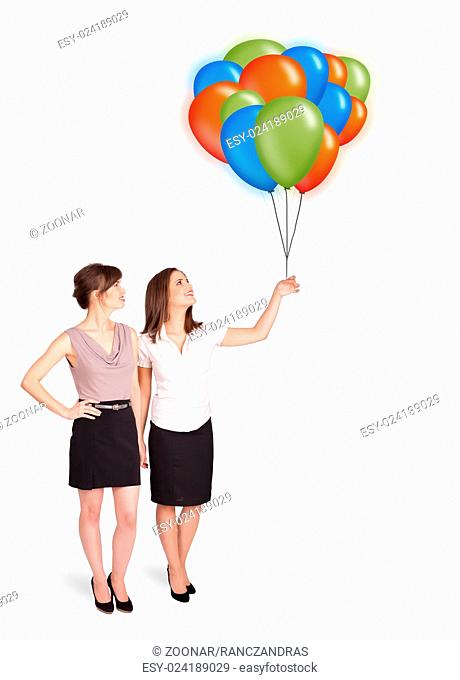 Young women holding colorful balloons