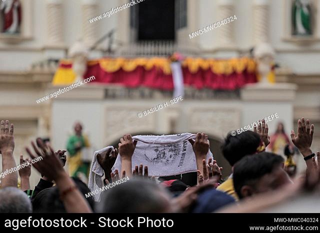 Filipino Catholic devotees raise miniature replicas of the Black Nazarene in Manila. A mammoth crowd of mostly barefoot Filipino Catholics prayed for peace in...