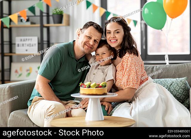 happy family with birthday cake hugging at home