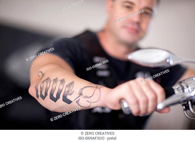 Close up of mature man sitting on motorcycle indoors