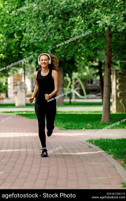young attractive woman running in summer park