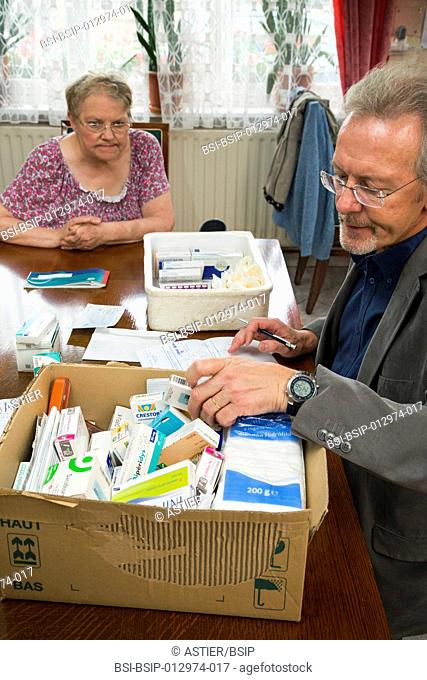 To be used only in the context of the feature. Country doctor making house call, Nord-Pas-de-Calais, France. The doctor sorting drugs