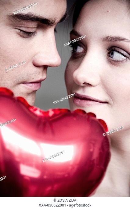 close-up of couple with heart-shaped balloon