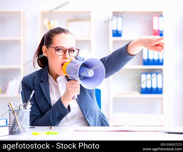 The angry businesswoman yelling with loudspeaker in office