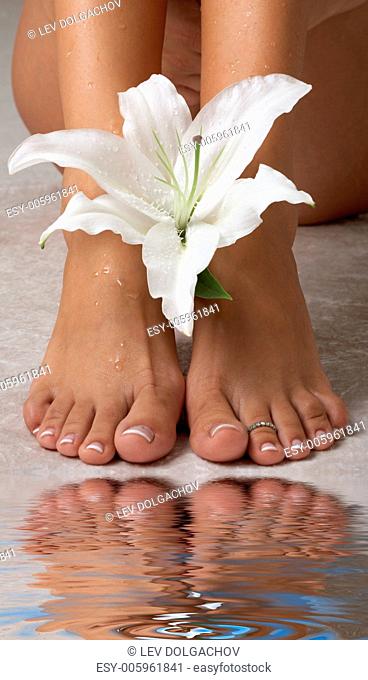 beautiful female feet with madonna lily in spa