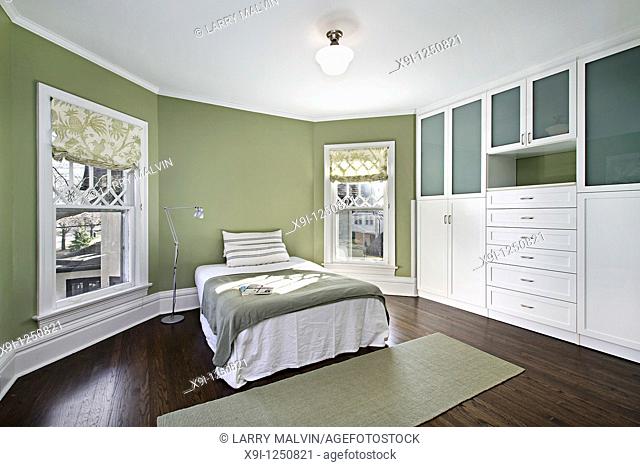 Master bedroom with green walls and dark wood flooring