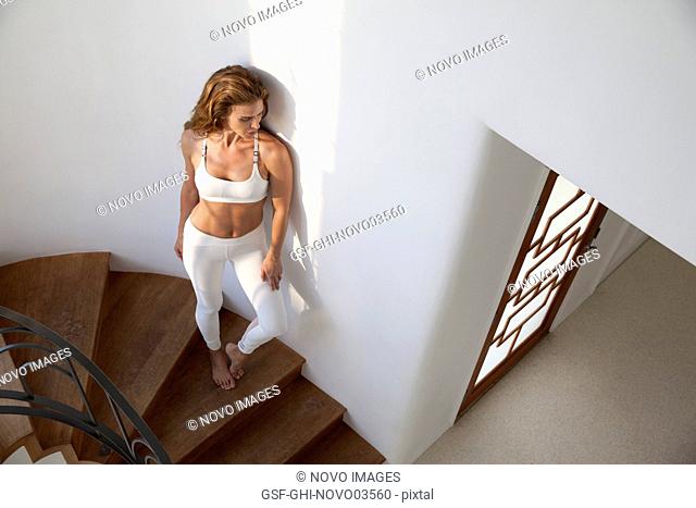 Full-Length Portrait of Mid-Adult Woman in Fitness Attire Standing on Stairs, High Angle View