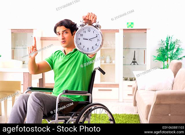 Young handsome man in wheelchair at home