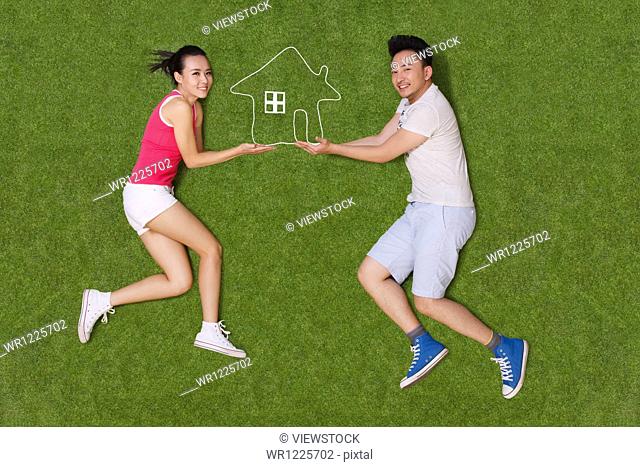 Young people lying on grass with an artificial house