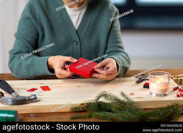 close up of woman packing christmas gift at home