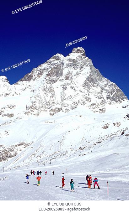 Skiers on slopes at the foot of the Matterhorn