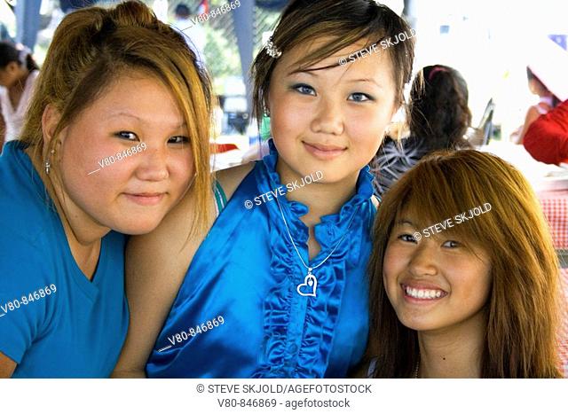 Three teen girls SE Asian Hmong enjoying the cultural festivities Hmong Sports Festival McMurray Field St Paul Minnesota USA