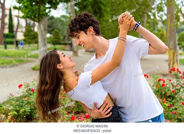 Young couple dancing in a park