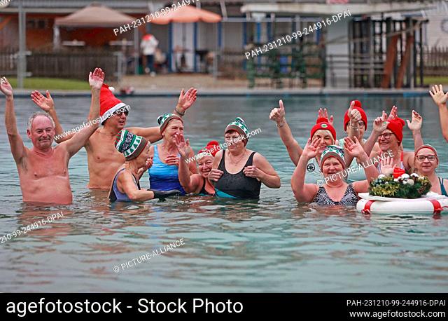 10 December 2023, Saxony-Anhalt, Osterwieck: Participants in the Advent swim stand in the water at 6 degrees Celsius in the Osterwieck outdoor pool