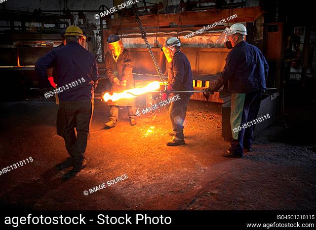 Red hot steel billet which has already been partially pre formed is moved back in to the furnace