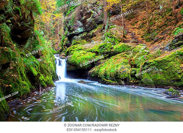 Waterfall in Doubravka valley in autumn, Highlands in Czech Republic. Autumn scenery. Long exposure