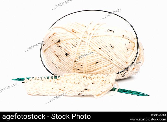 Beige knitting wool or yarn with knitting needles