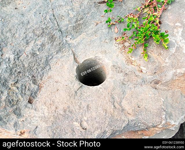 grey rock or boulder with circular drilled hole