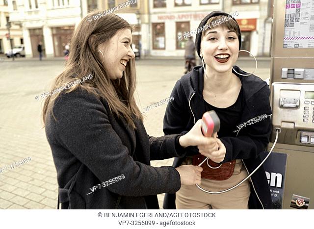 two woman holding payphone, happiness, in city Cottbus, Brandenburg, Germany