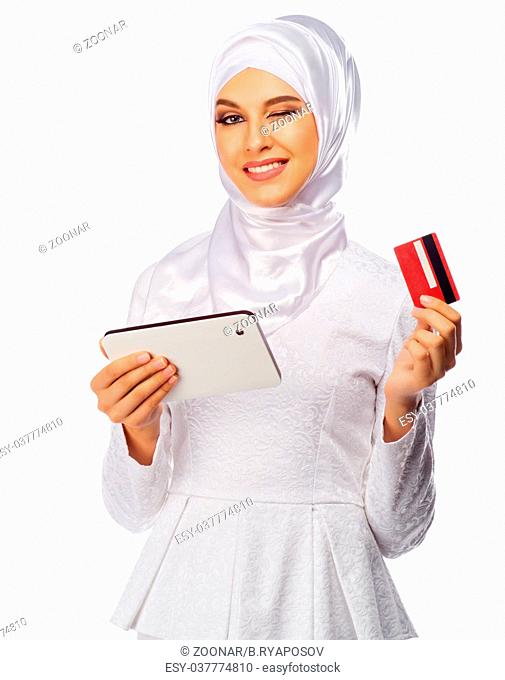 Young muslim woman with tablet PC and plastic card isolated