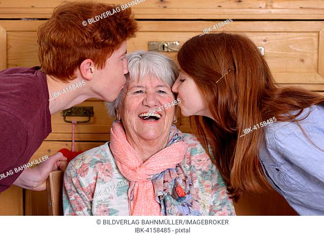 Grandmother getting a kiss from her grandchildren, Bavaria, Germany