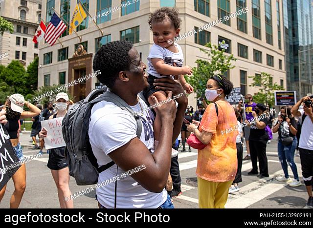 Nyron Dancy holds up his 1-year-old daughter Ny’omi Dancy during a march against police brutality and racism in Washington, D.C