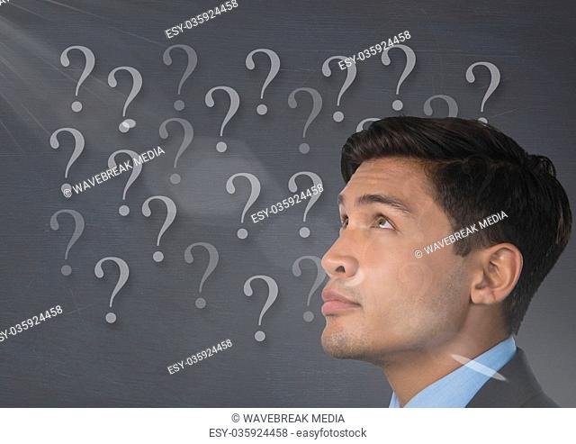 man looking up at question marks