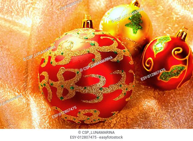 Christmas red baubles on golden fabric