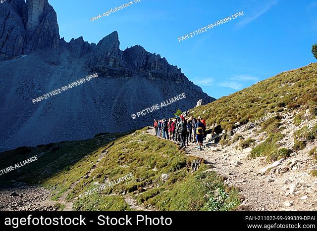 05 October 2021, Italy, Sexten: Hikers near the Langalm Hut at the Three Peaks (Italian: Tre Cime di Lavaredo) in the Sesto Dolomites