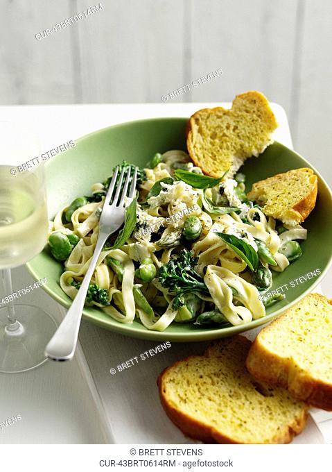 Bowl of pasta with peas and toast