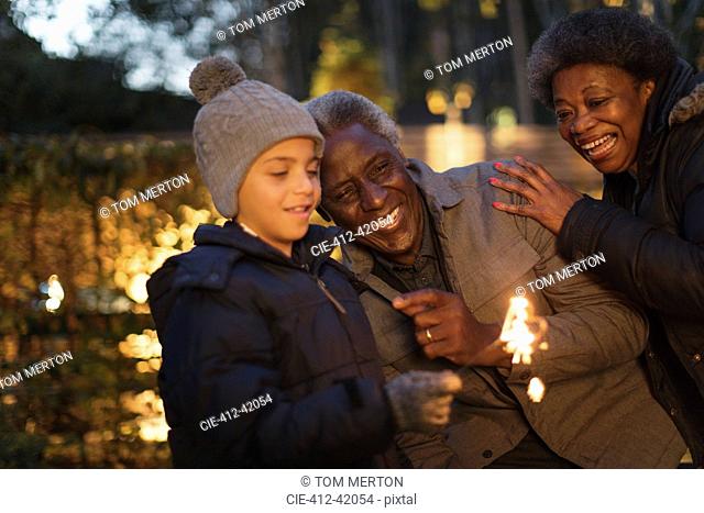 Grandparents and grandson playing with firework sparkler
