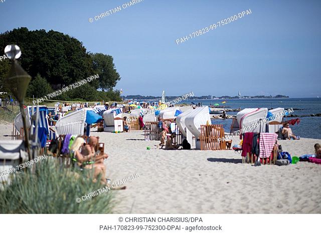 Beach-goers resting under the shining sun in front of the Baltic Sea near Sierksdorf, Germany, 23 August 2017. Photo: Christian Charisius/dpa