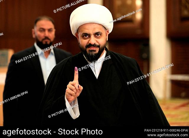 18 December 2023, Iraq, Baghdad: Head of Iraq's Asaib Ahl al-Haq Qais Khazali shows his ink-stained finger after voting in the first provincial council...
