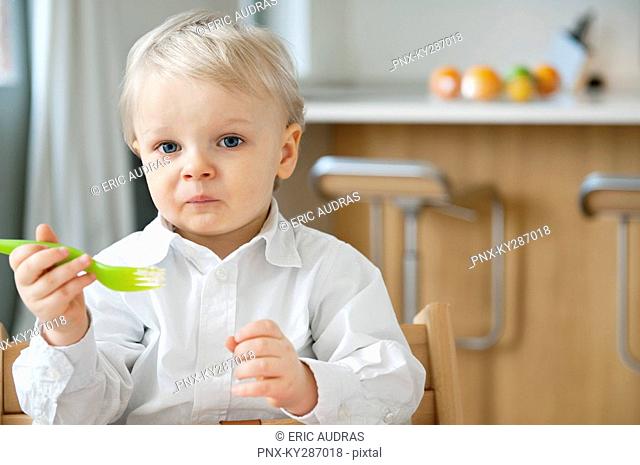 Boy eating with a fork and making a face