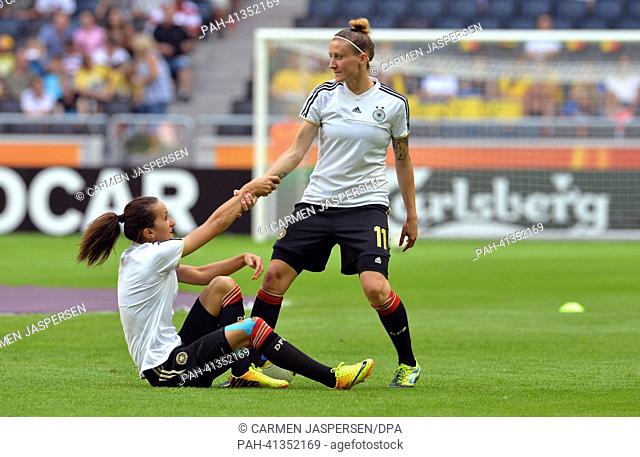Fatmire Bajramaj (L) and Anja Mittag of Germany help together before the UEFA Women«s EURO 2013 final soccer match between Germany and Norway at the Friends...