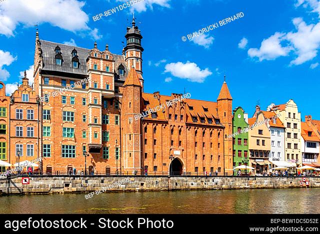 Gdansk, Pomerania / Poland - 2020/07/14: Mariacka Gate and Archeological Museum along the Hanseatic houses pier at Motlawa river embankment in old town city...