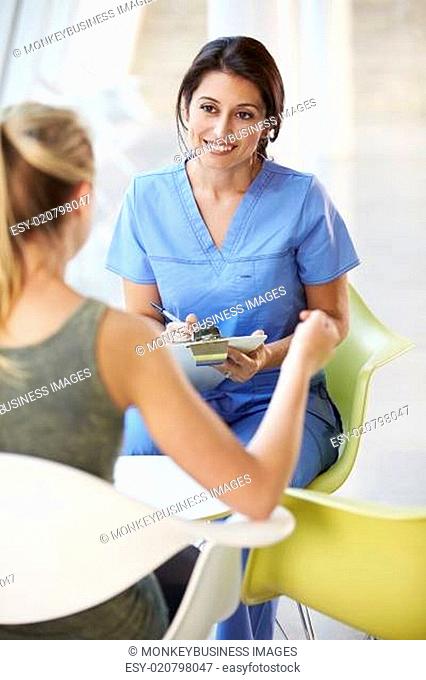 Nurse Meeting With Teenage Girl In Modern Hospital