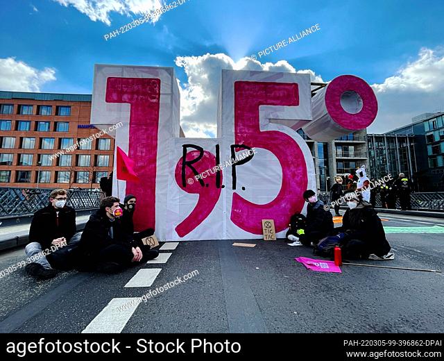 05 March 2022, Berlin: An oversized number has been placed on the Marshall Bridge by supporters and members of the environmental movement Extinction Rebellion