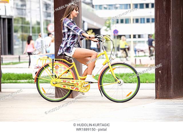 Young woman riding bicycle, Osijek, Croatia