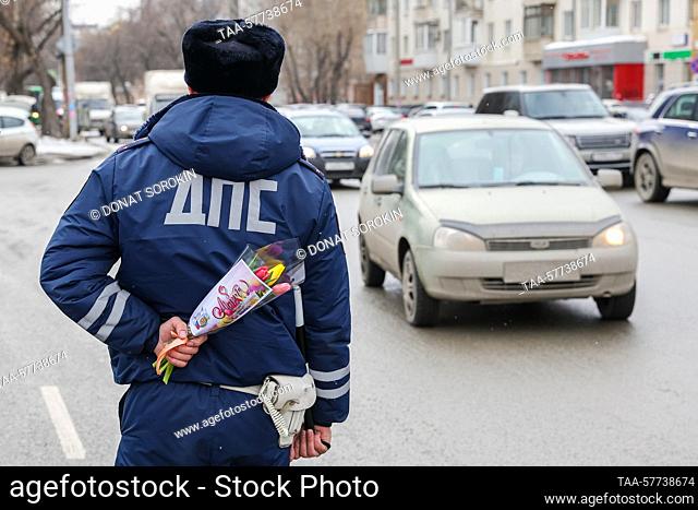 RUSSIA, YEKATERINBURG - MARCH 7, 2023: A traffic police officer has flowers to congratulate passing women drivers on 8 Marta Street ahead of International...