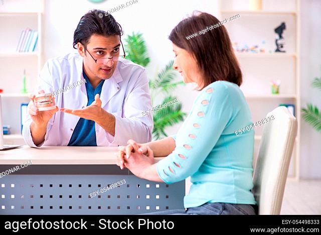 The middle-aged woman visiting male doctor stomatologist